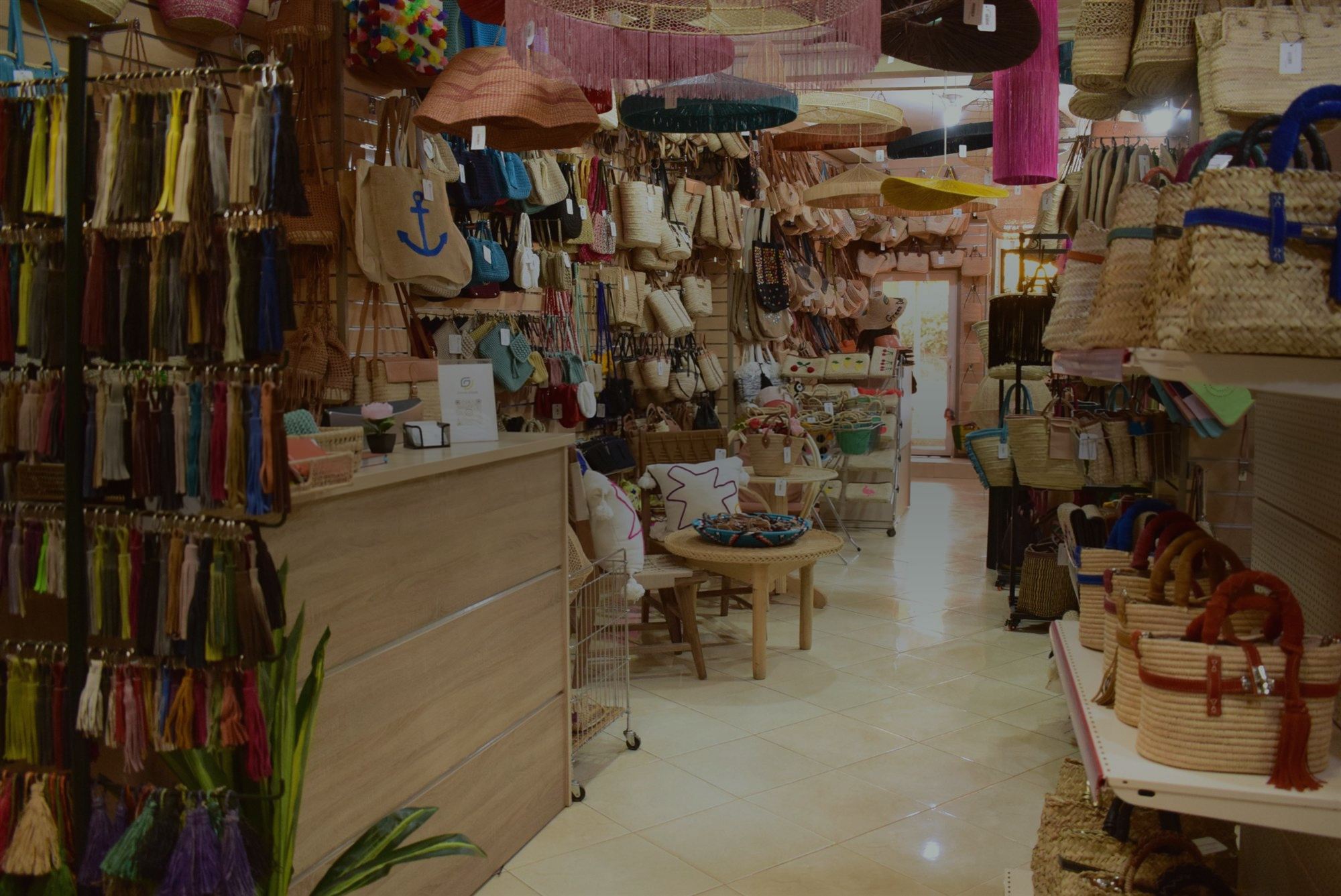 Aisle of the Green Doum showroom with handmade straw bags, tassels and lampshades