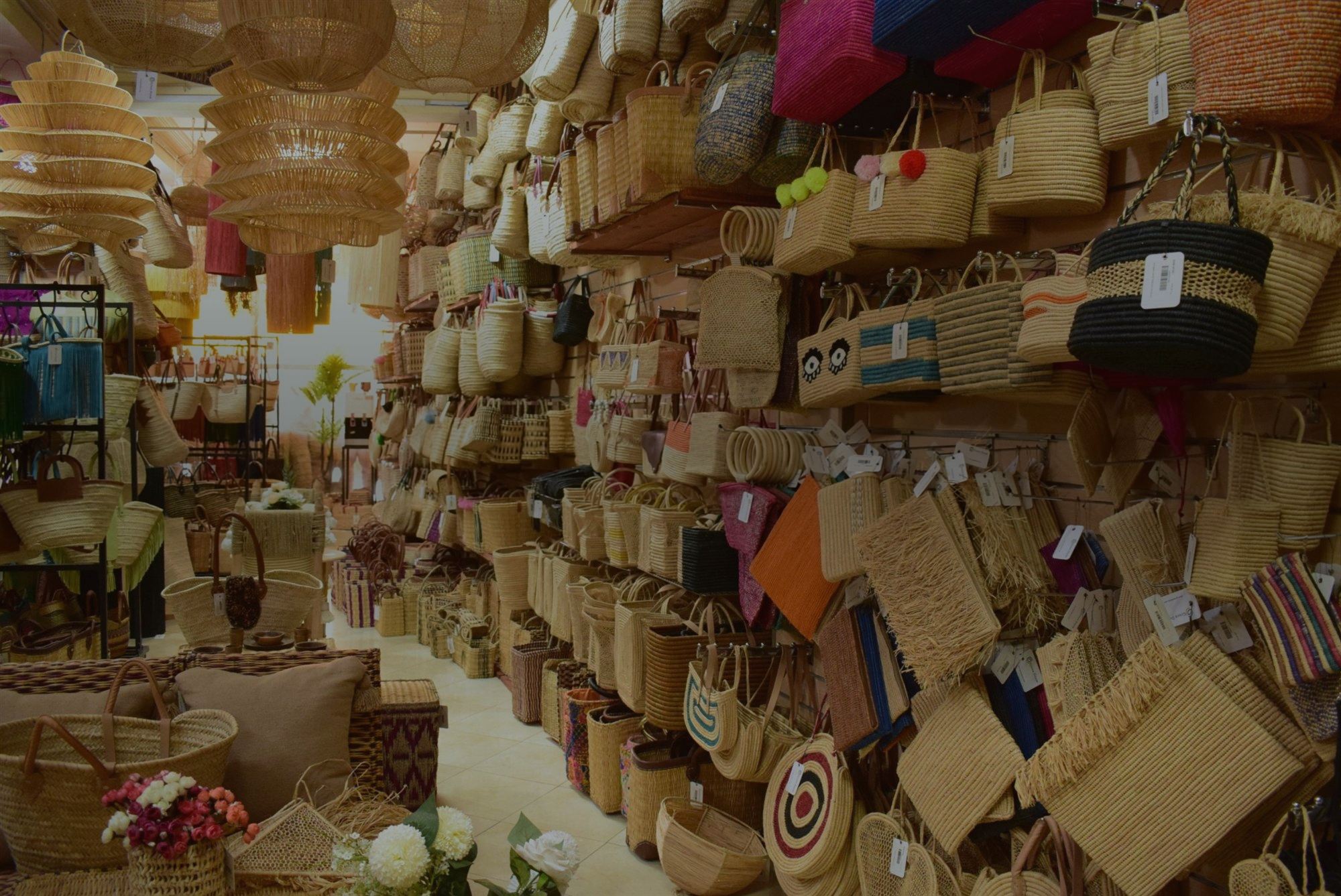 Wall of handmade Moroccan straw bags and baskets in the Green Doum showroom